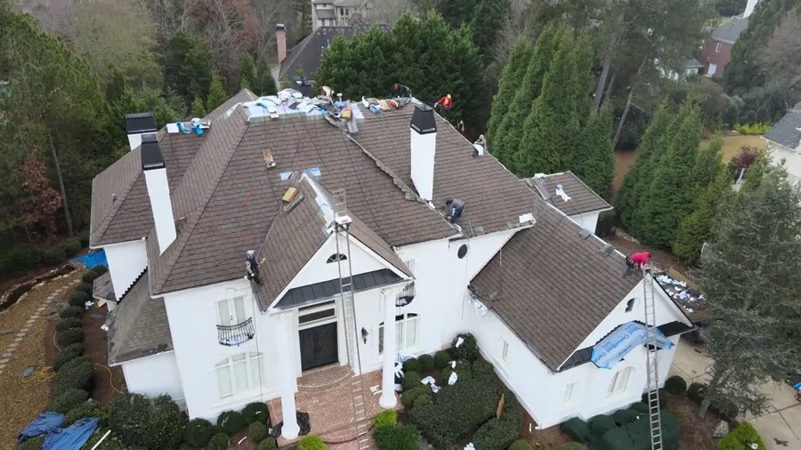 Drone pass across the front of the house with the crew on the roof